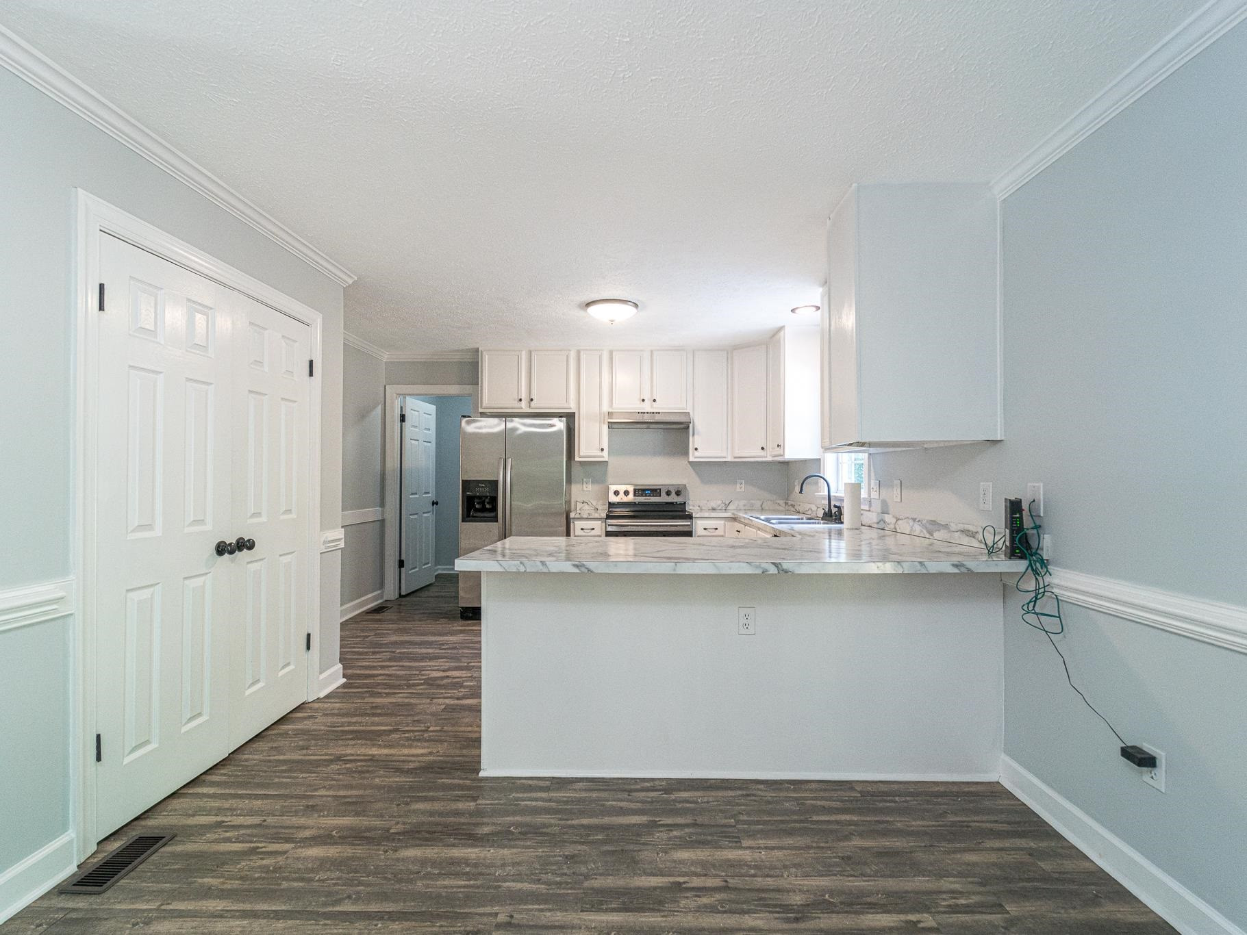 9961 Old Middlesex Road Middlesex, NC 27557 - Photo 9 of 30 a kitchen with stainless steel appliances granite countertop a refrigerator sink and white cabinets
