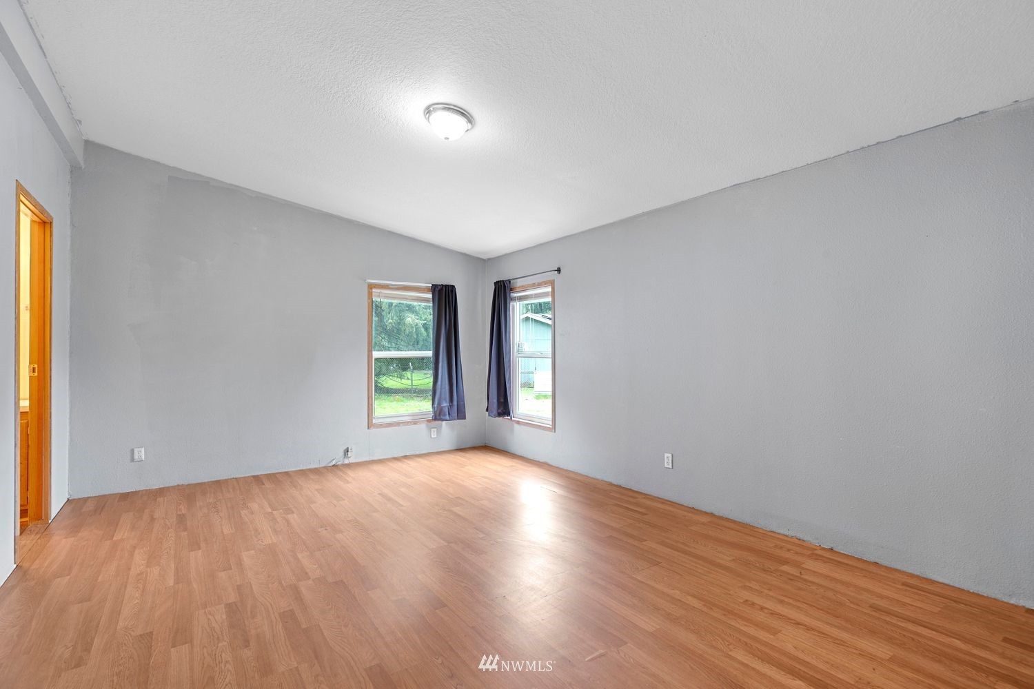 6323 190th Lane Southwest Rochester, WA 98579 - Photo 8 of 17 a view of an empty room with wooden floor and a window