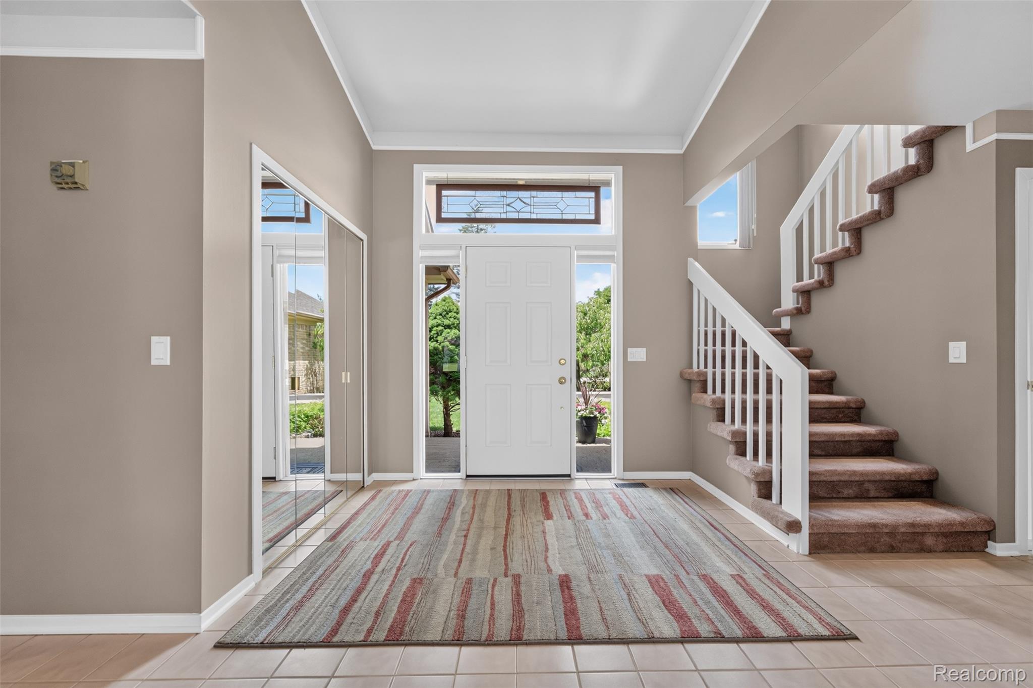 1236 Chaffer Drive Rochester, MI 48306 - Photo 5 of 76 Foyer featuring a white entry door with a transom window, ceramic tile flooring, a carpeted staircase with white railings, mirrored closet doors, and recessed lighting
