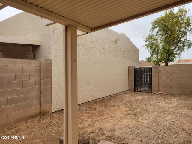 a view of an empty room with a brick wall and a window