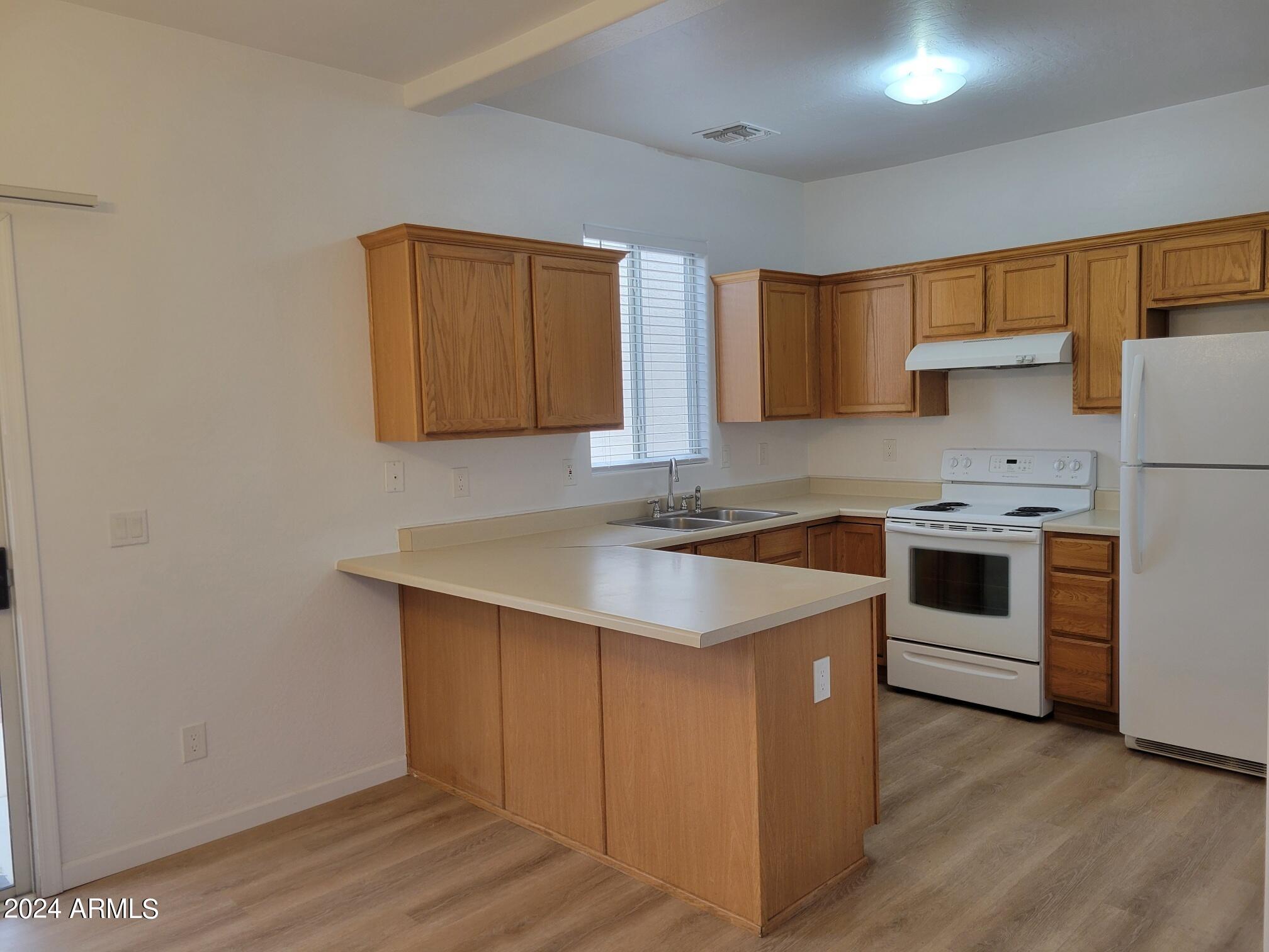 2300 East Magma Road, Unit 170 San Tan Valley, AZ 85143 - Photo 7 of 22 a kitchen with a stove a sink and a refrigerator