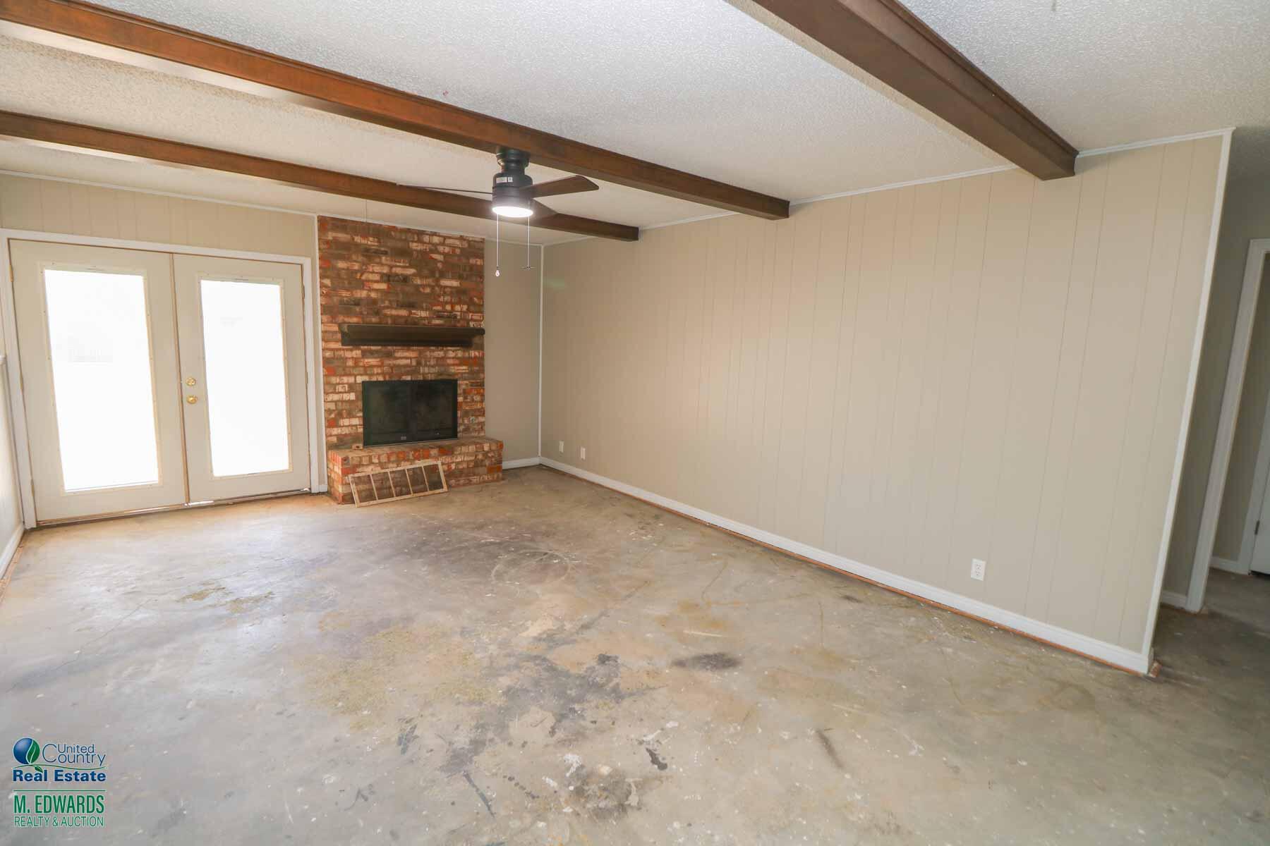 705 West Virginia Street Floydada, TX 79235 - Photo 4 of 15 a view of an empty room with a fireplace and a window