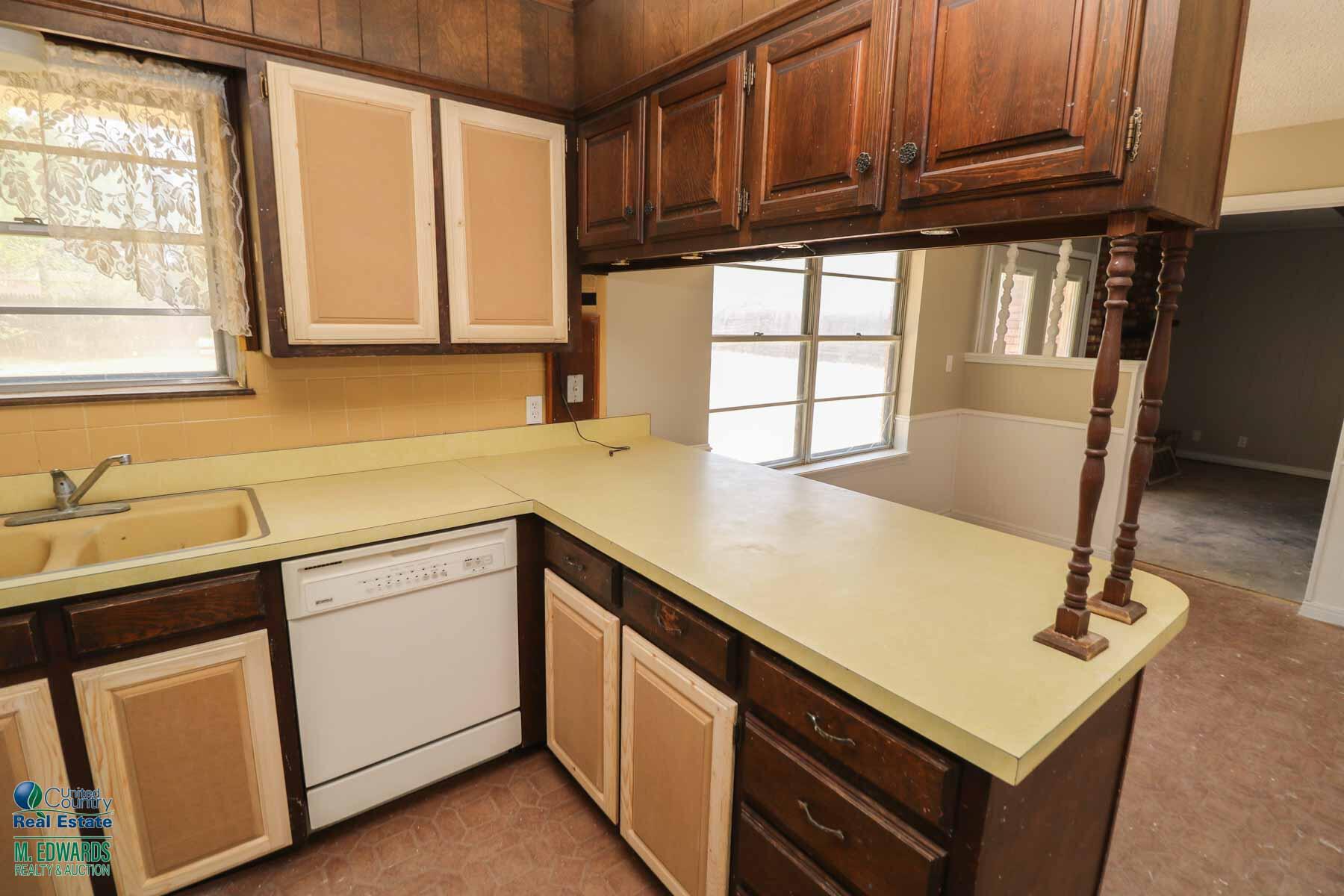705 West Virginia Street Floydada, TX 79235 - Photo 7 of 15 a kitchen with stainless steel appliances a sink a stove cabinets and a window