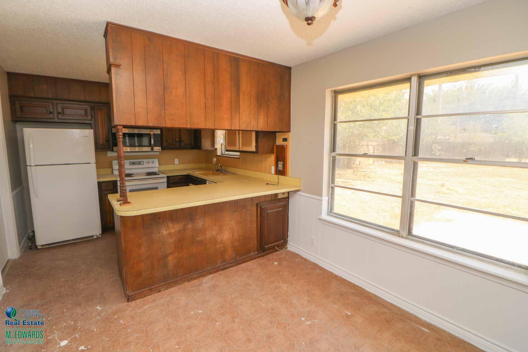 705 West Virginia Street Floydada, TX 79235 - Photo 9 of 15 a kitchen with a refrigerator stove and cabinets