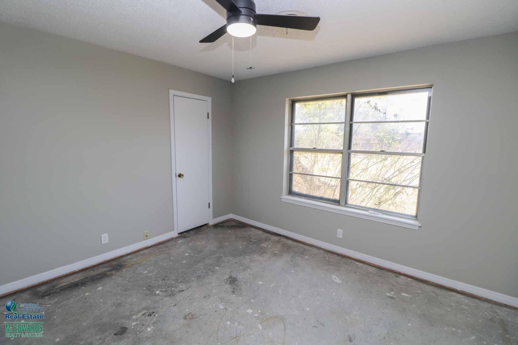 705 West Virginia Street Floydada, TX 79235 - Photo 10 of 15 an empty room with a window and a fan
