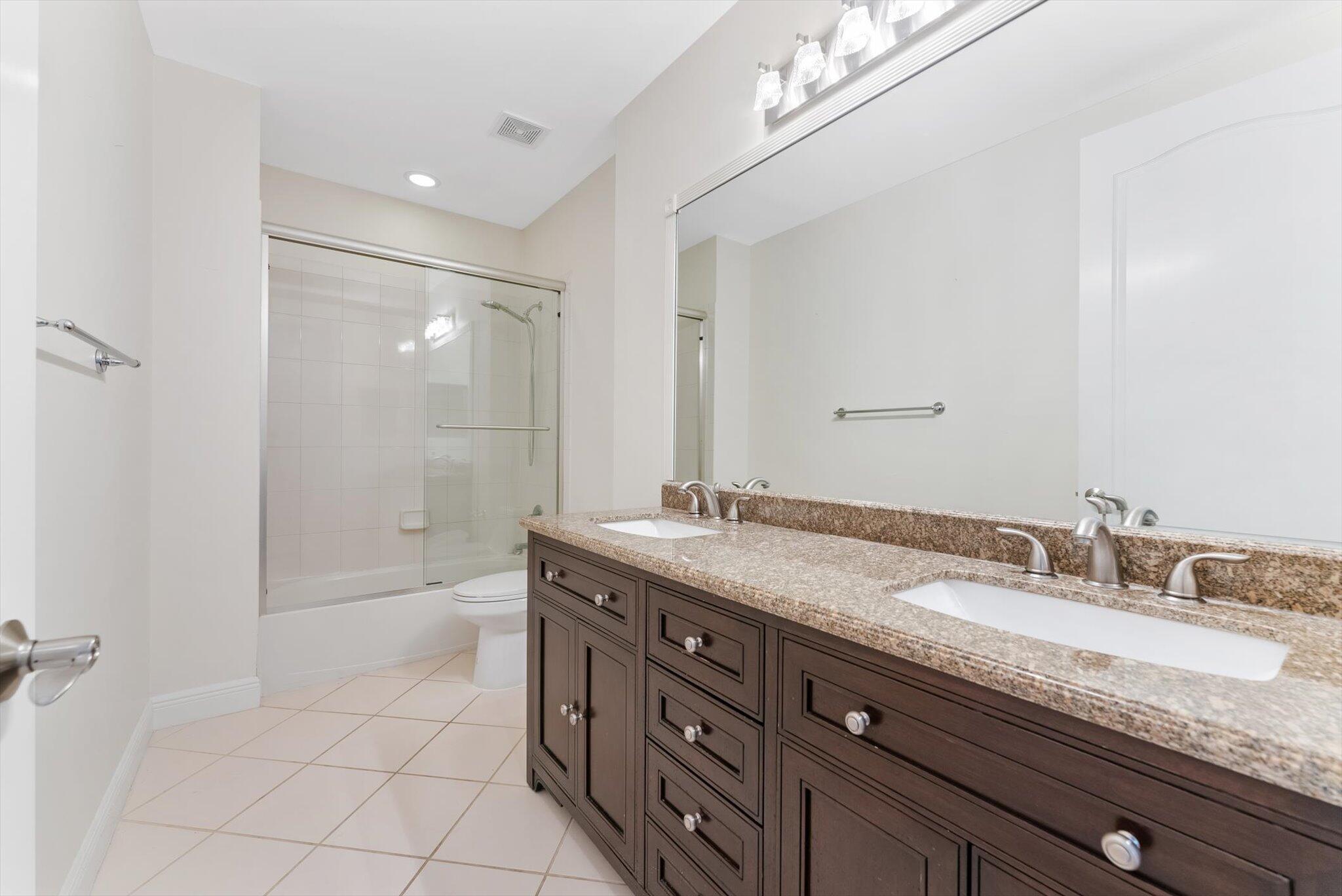 604 Northeast Francesca Lane Boca Raton, FL 33487 - Photo 25 of 55 a bathroom with a granite countertop sink a mirror and a shower