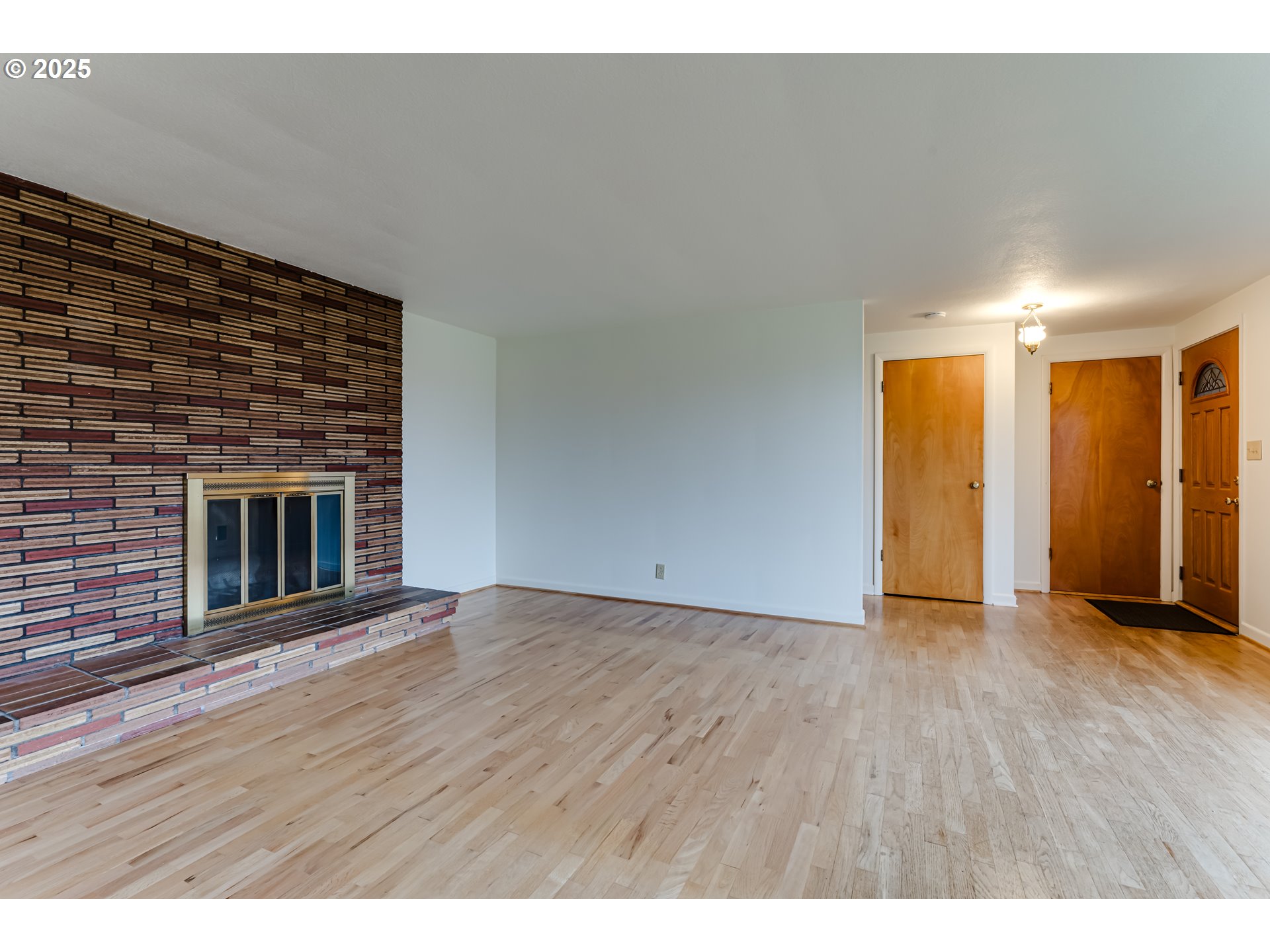 2550 Lawrence Street Eugene, OR 97405 - Photo 11 of 48 a view of an empty room with wooden floor and a fireplace