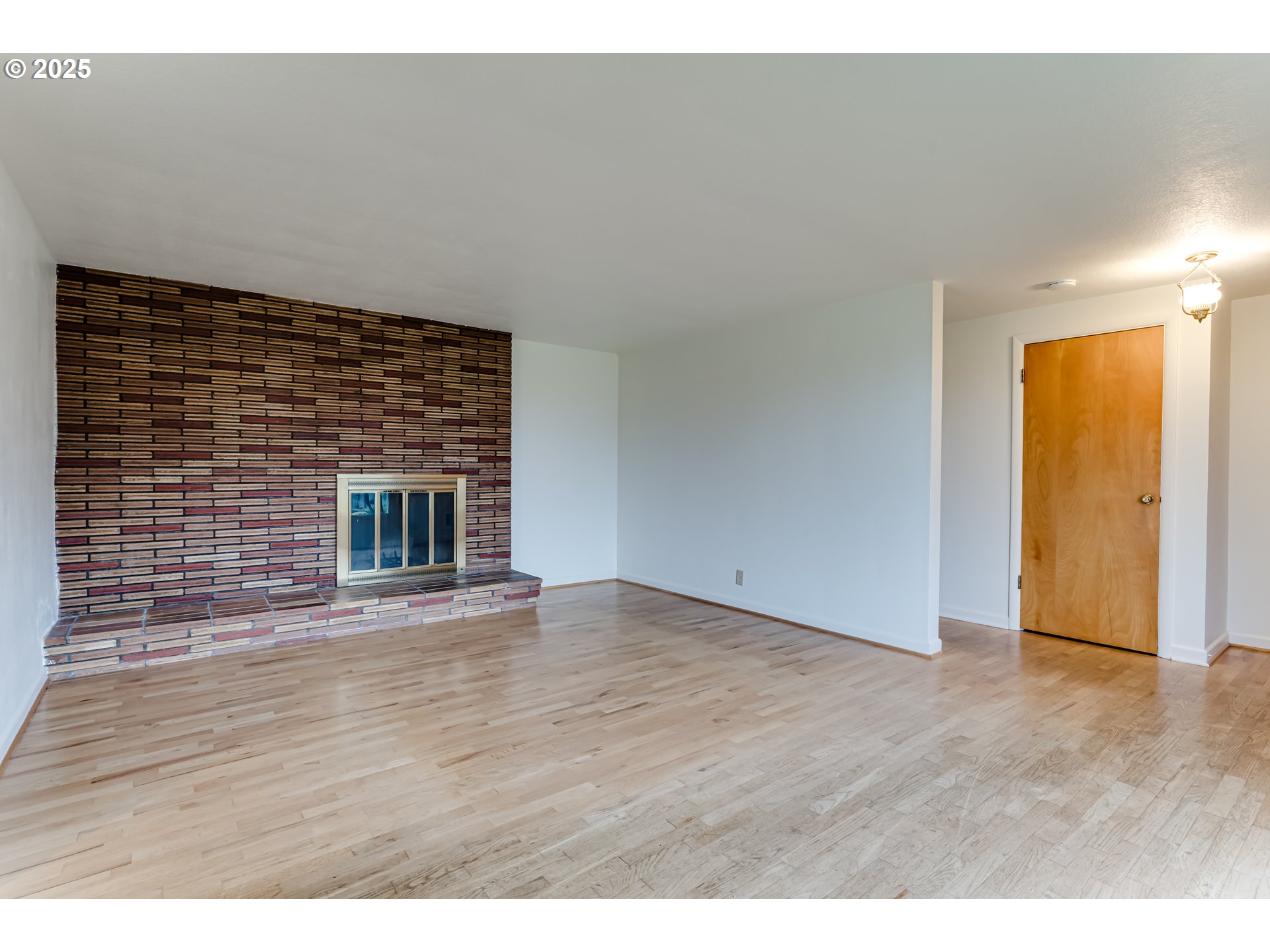 2550 Lawrence Street Eugene, OR 97405 - Photo 12 of 48 a view of an empty room with wooden floor and a fireplace