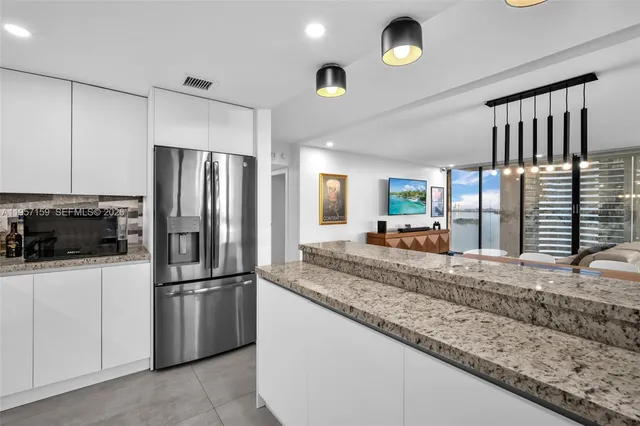 a kitchen with stainless steel appliances granite countertop a refrigerator sink and stove