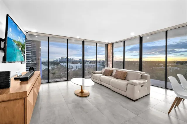a living room with furniture and a floor to ceiling window