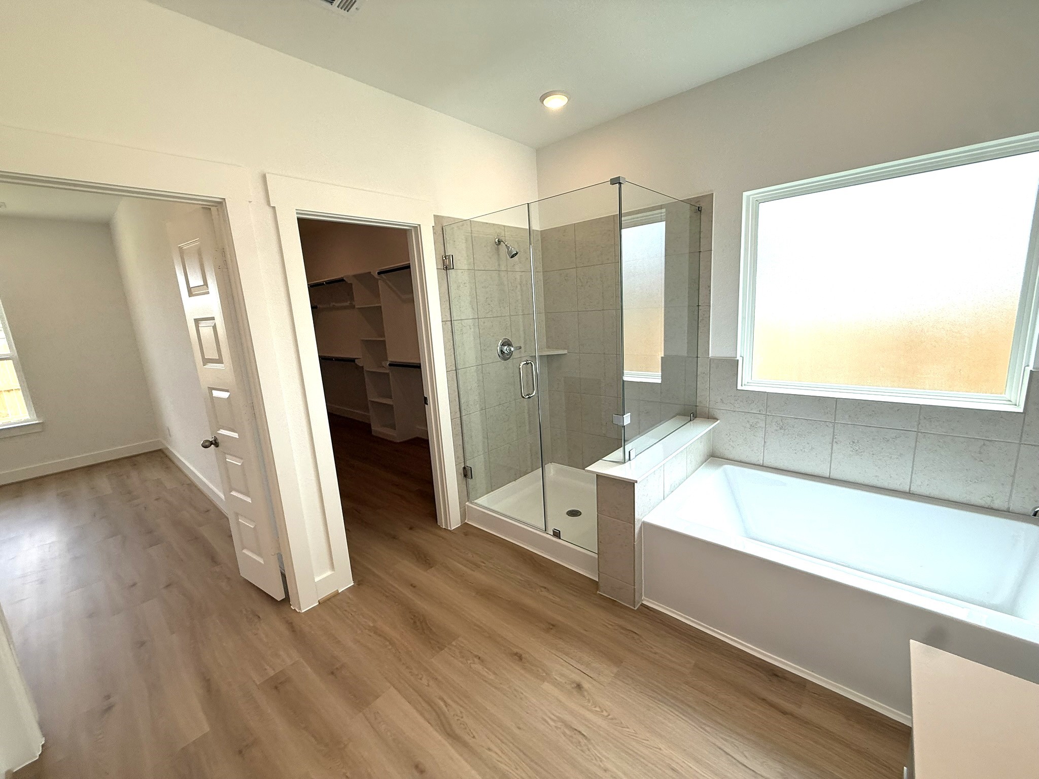 5314 Grace Sunshine Spring Spring, TX 77379 - Photo 14 of 23 A spacious walk-in shower, elegant tilework, and premium fixtures offers a refreshing start to the day, while the soaking tub provides the perfect place to unwind in the evenings.
