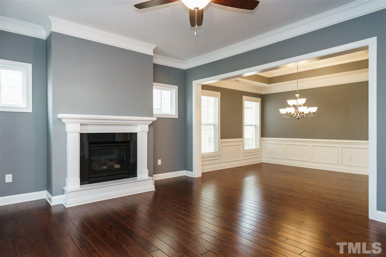 1334 Rodessa Run Raleigh, NC 27607 - Photo 5 of 25 a view of an empty room with wooden floor fireplace and a window