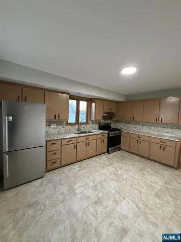 a kitchen with stainless steel appliances a refrigerator sink and cabinets