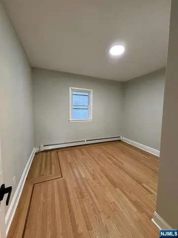 a view of a room with wooden floor and window