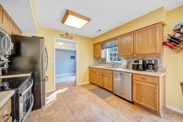 a kitchen with stainless steel appliances granite countertop a stove a sink and a refrigerator