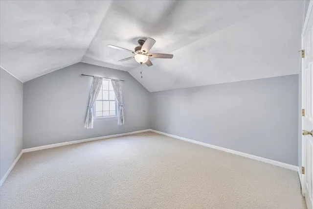 an empty room with windows and ceiling fan view