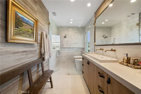 a large bathroom with a double vanity sink a toilet and a shower