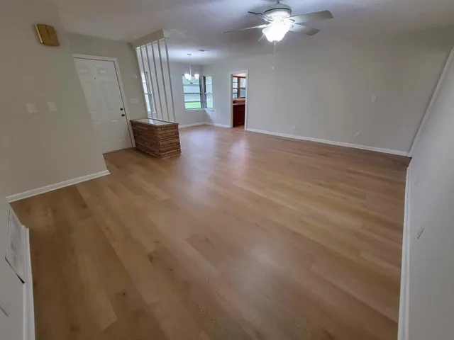 a view of a kitchen with stainless steel appliances wooden floor and window