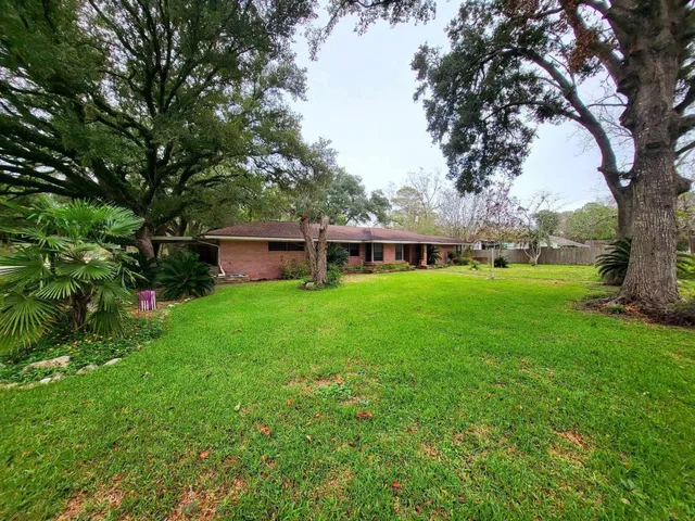 a view of a house with backyard and a tree