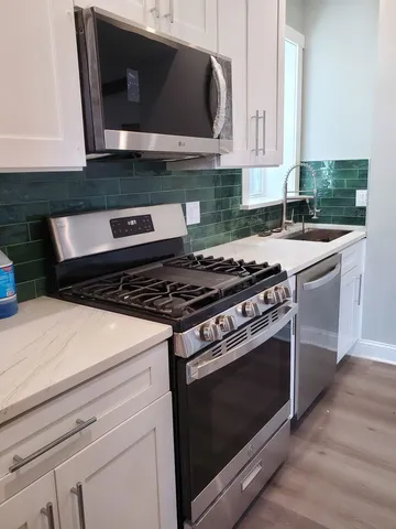 a stove top oven sitting inside of a kitchen