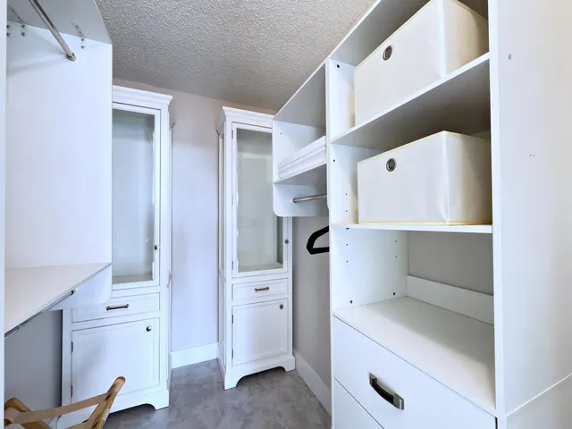 a living room with a bed and cabinets