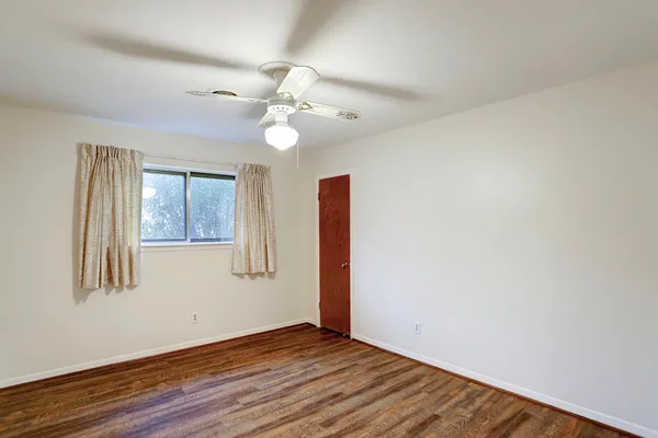 a view of an empty room with wooden floor