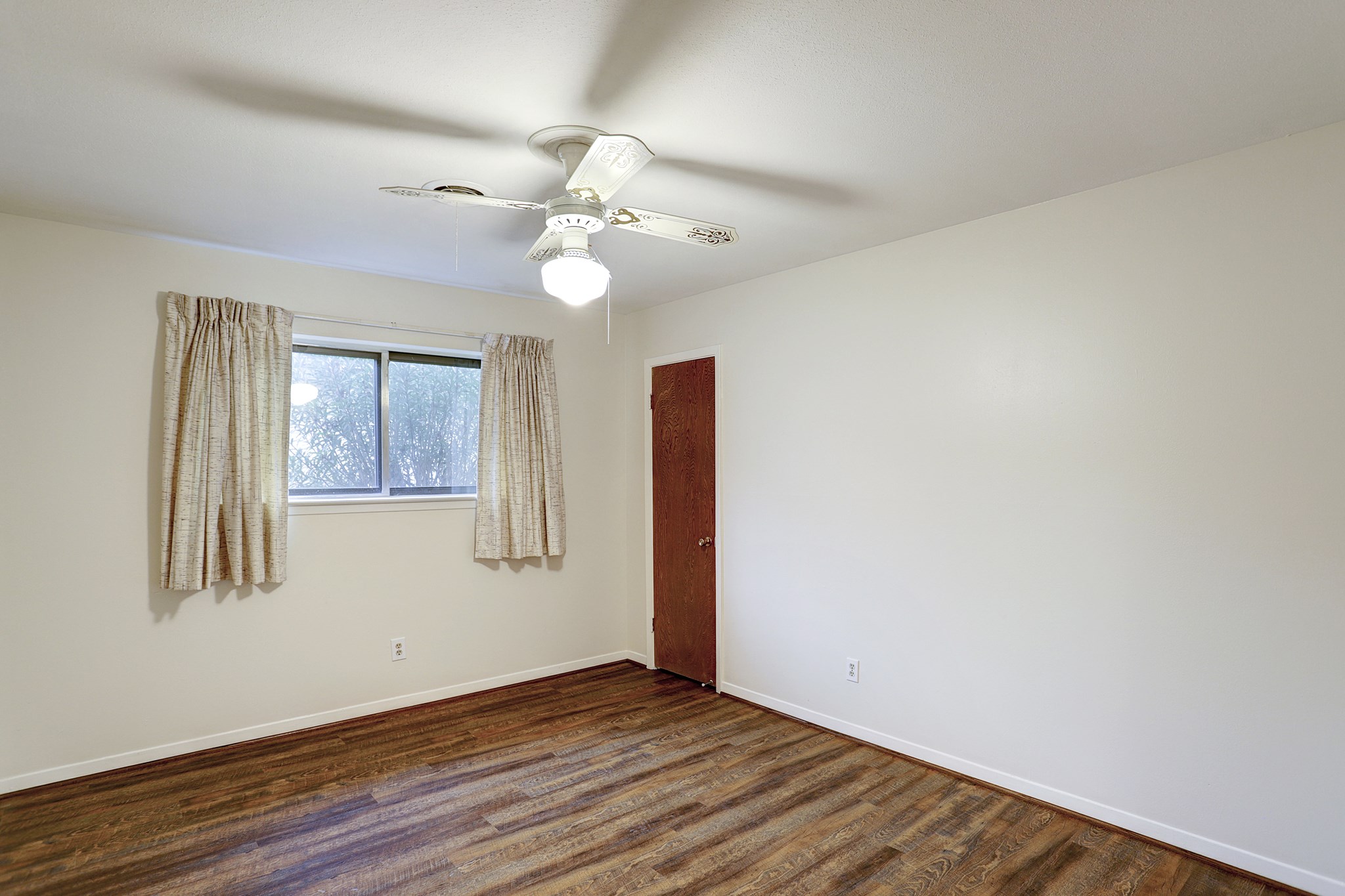 7739 Kensico Road Houston, TX 77036 - Photo 14 of 21 an empty room with wooden floor fan and windows