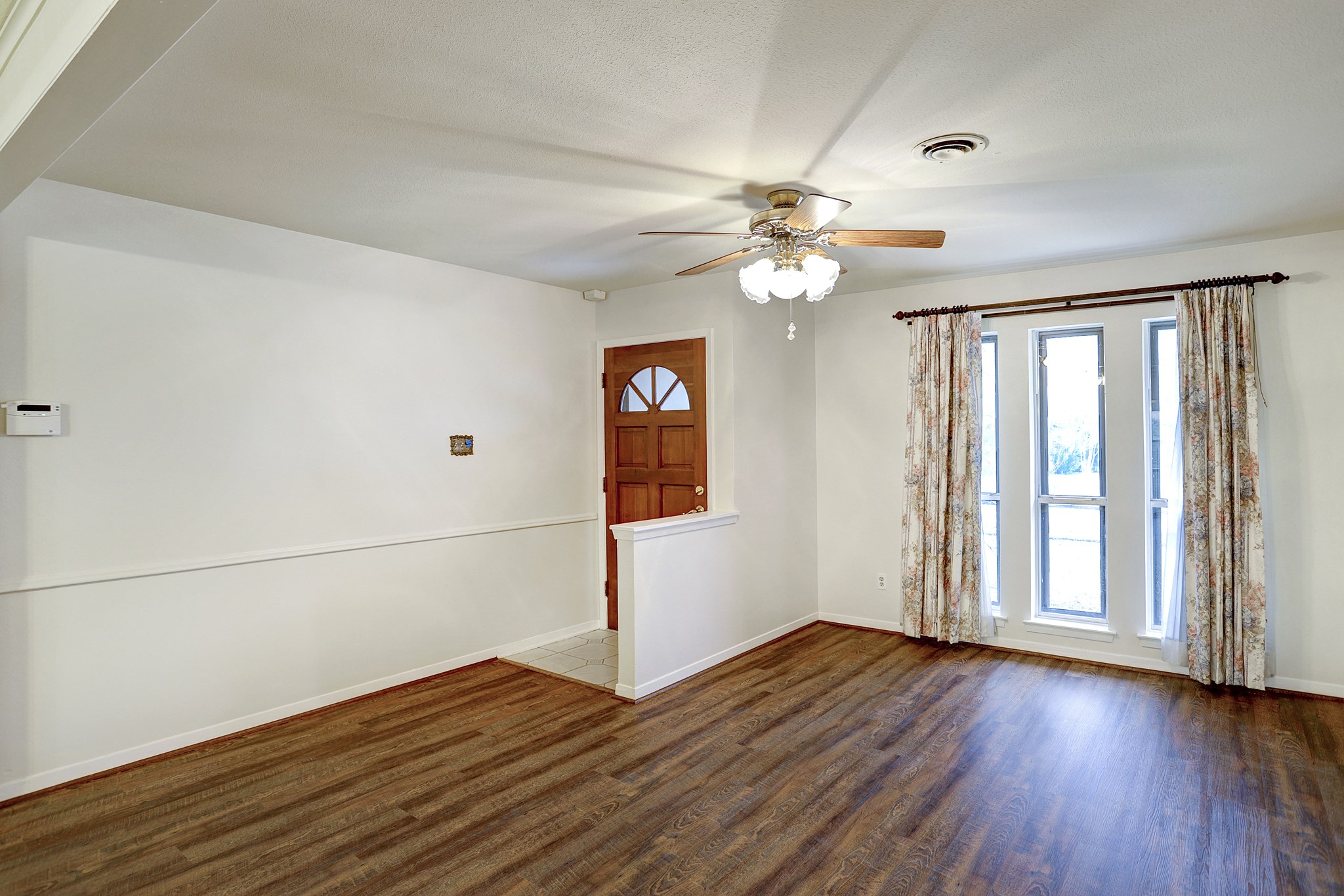 7739 Kensico Road Houston, TX 77036 - Photo 20 of 21 an empty room with wooden floor fan and windows