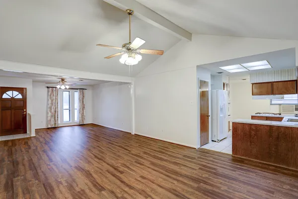 a view of empty room with wooden floor