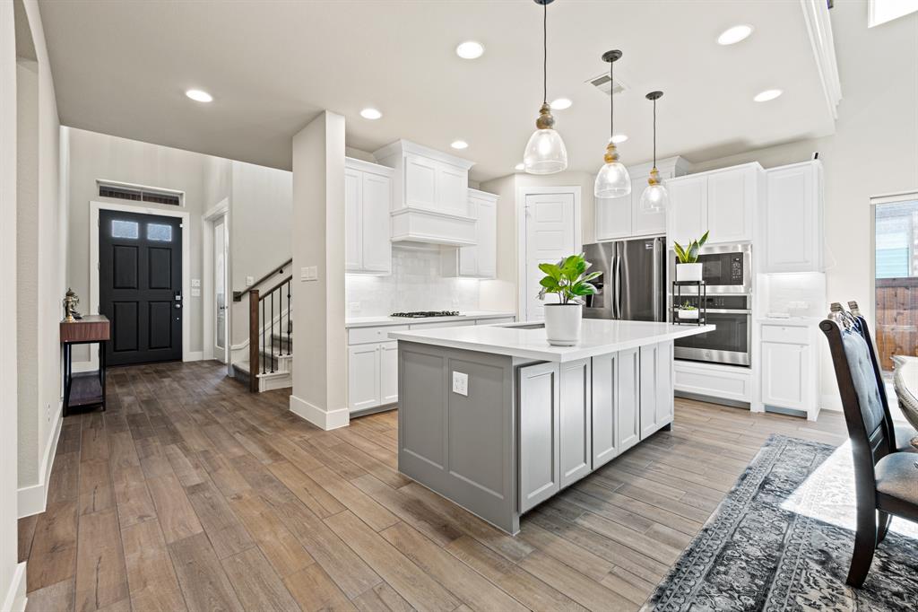 a kitchen with stainless steel appliances sink refrigerator and wooden floor