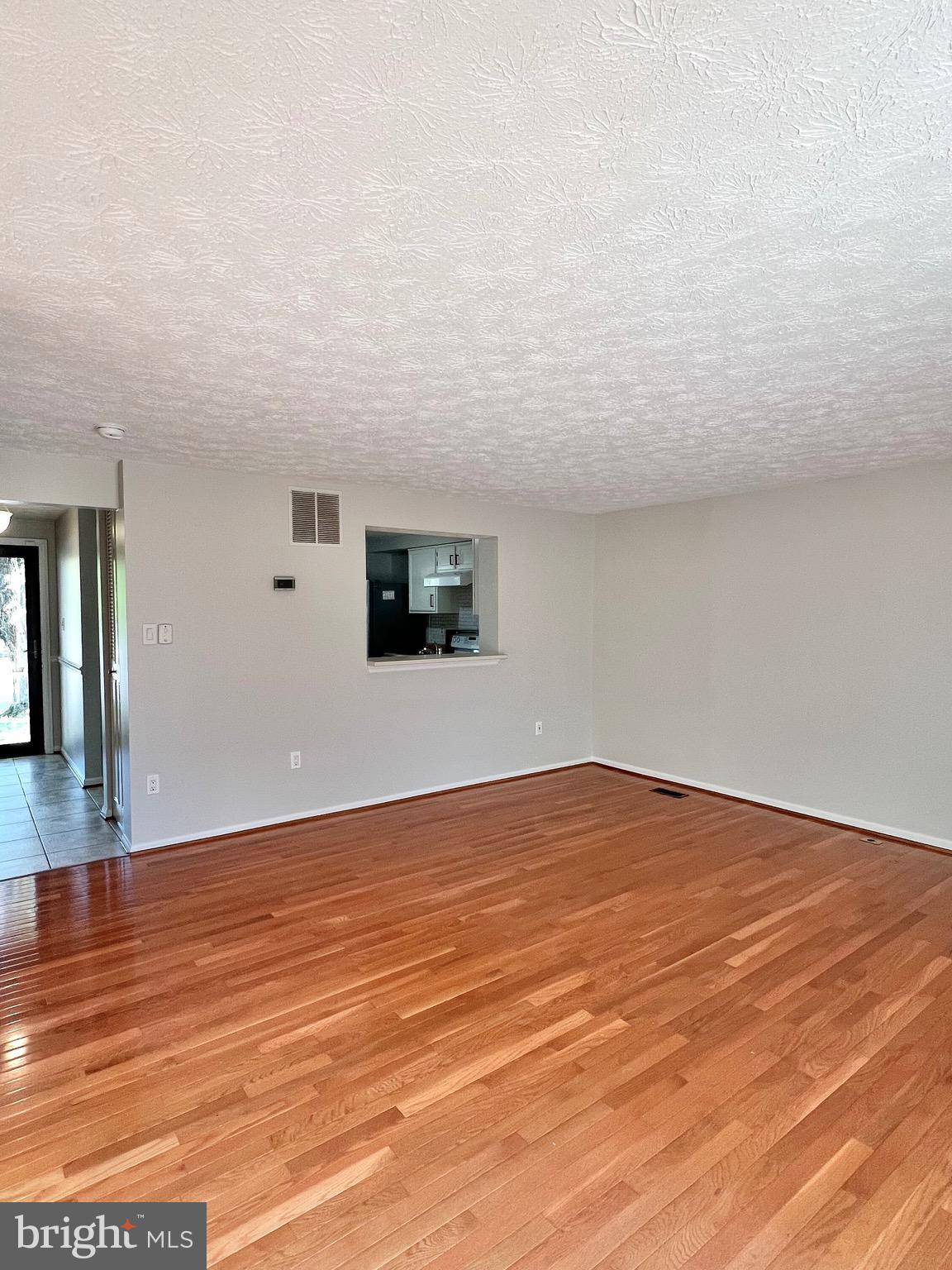 9624 Glendower Court Laurel, MD 20723 - Photo 11 of 26 a view of an empty room with wooden floor and a window