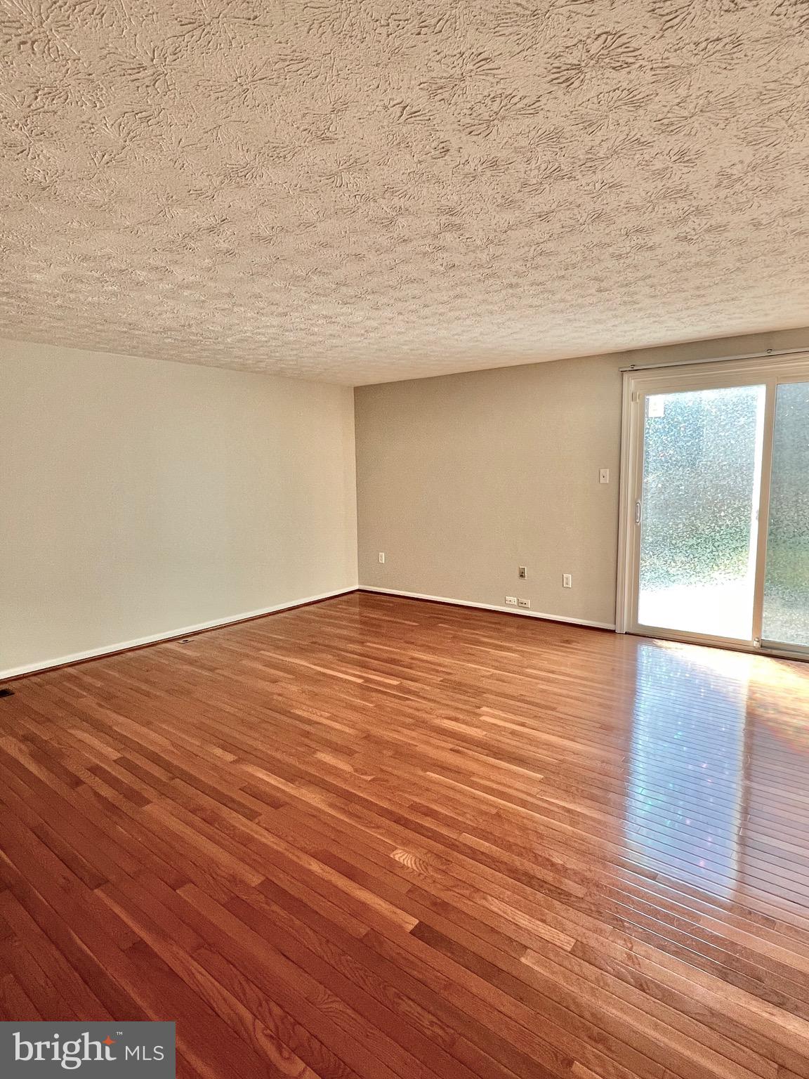 9624 Glendower Court Laurel, MD 20723 - Photo 10 of 26 an empty room with wooden floor and windows
