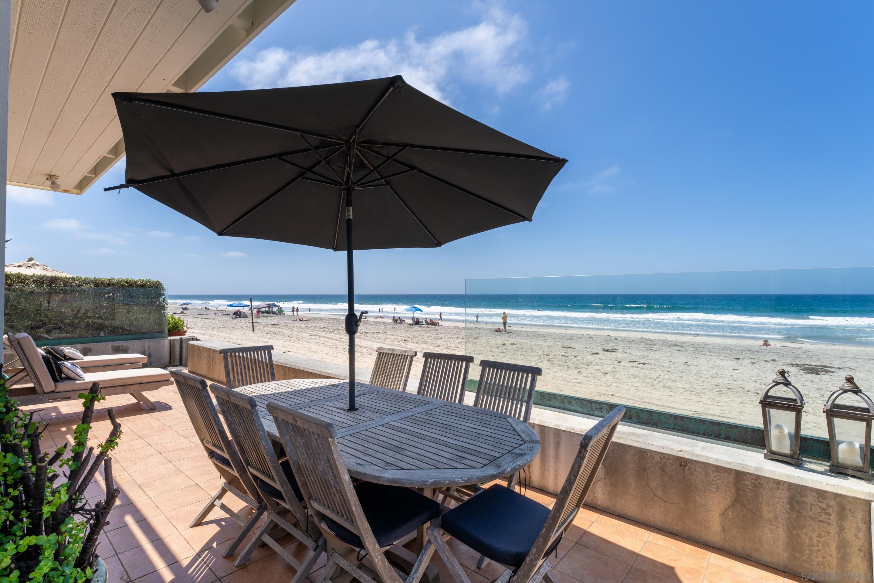 a view of a roof deck with table and chairs under an umbrella