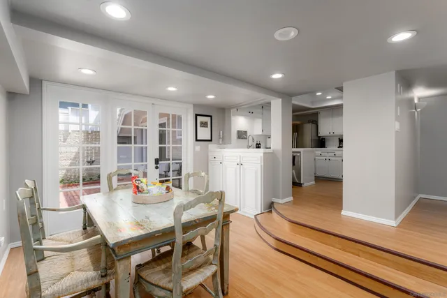 a living room with stainless steel appliances furniture and kitchen view