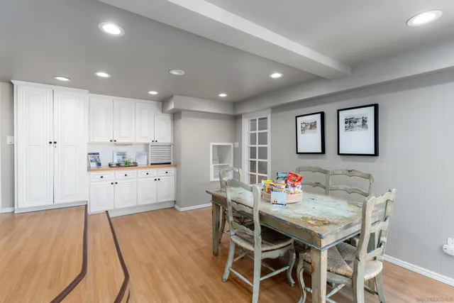 a kitchen with stainless steel appliances kitchen island granite countertop a dining table chairs and white cabinets