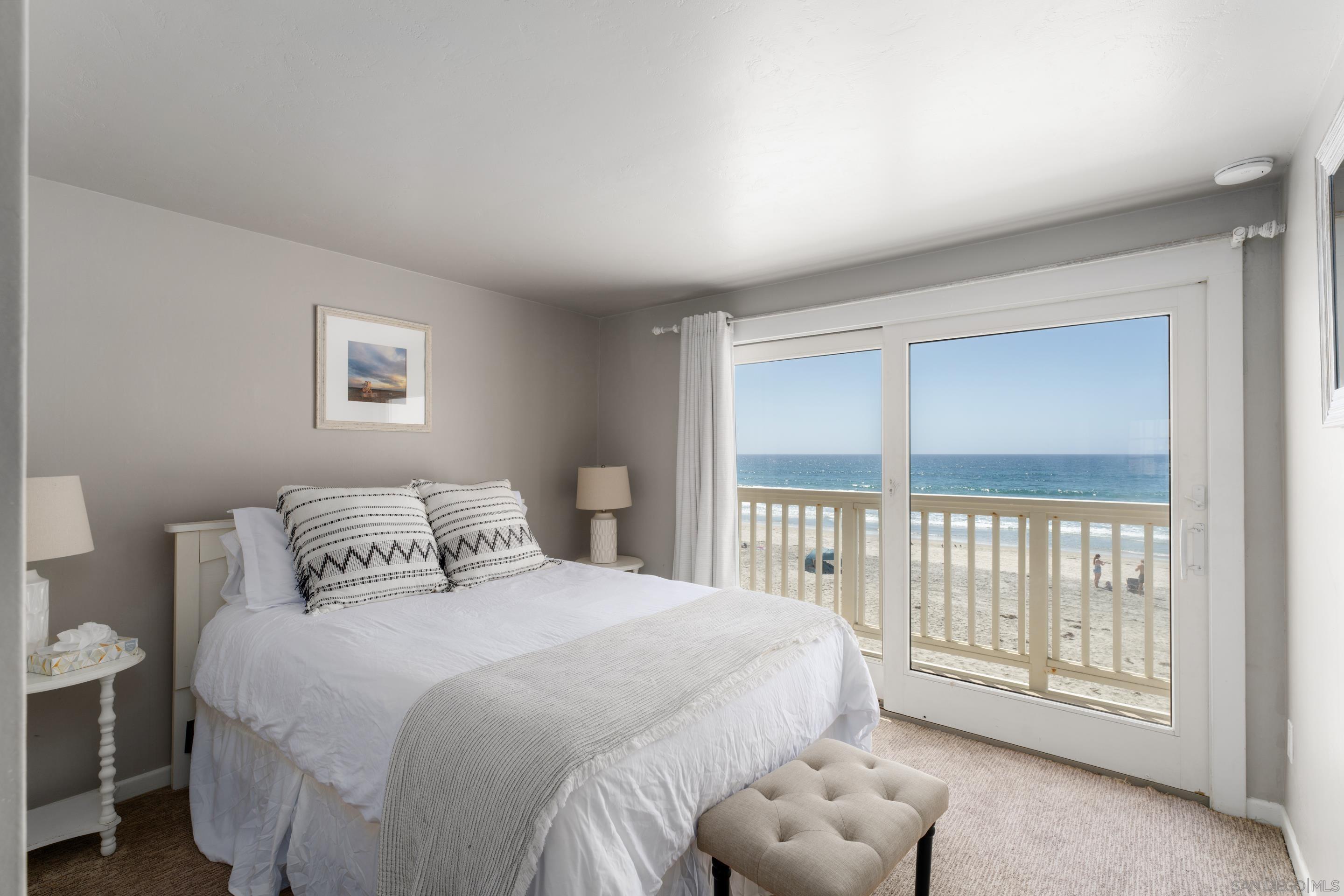 1834 Ocean Front Del Mar, CA 92014 - Photo 14 of 36 a bedroom with a large bed and a large window