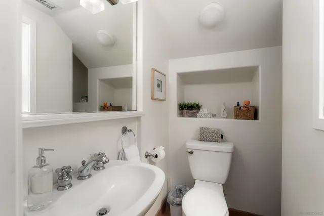 a bathroom with a toilet sink and mirror