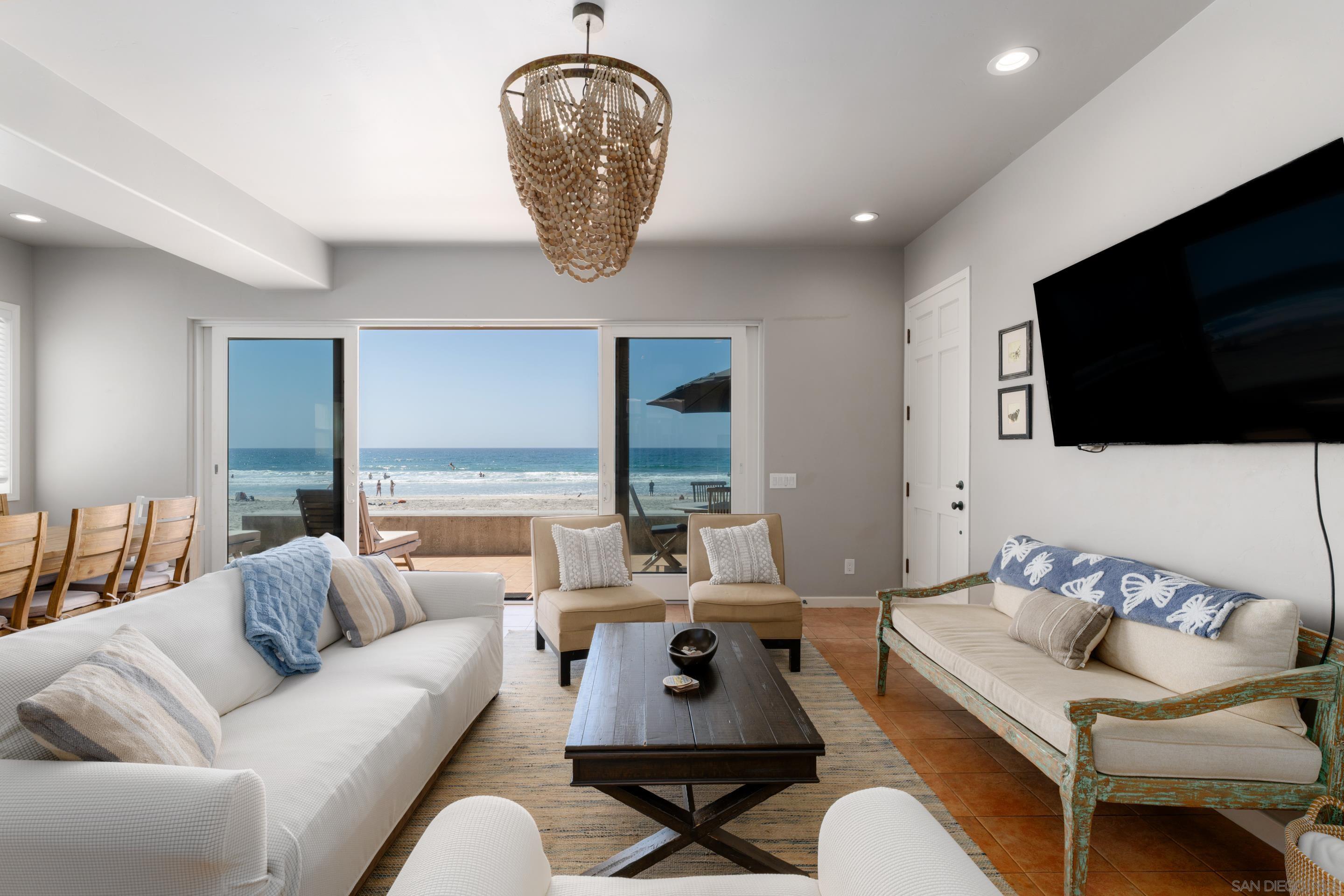 1834 Ocean Front Del Mar, CA 92014 - Photo 6 of 36 a living room with furniture a flat screen tv and a large window