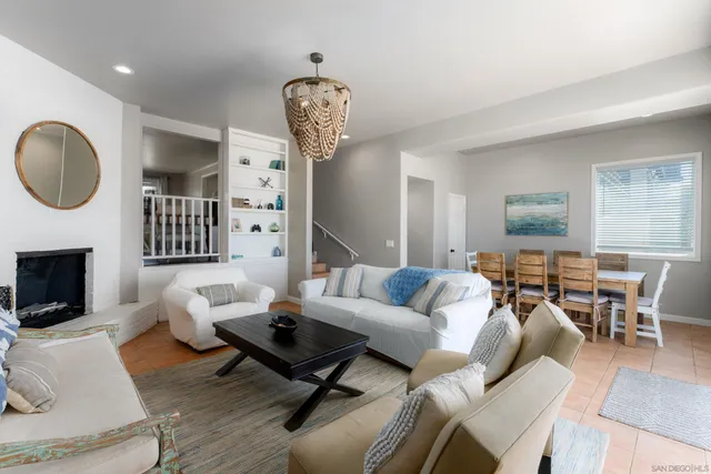a living room with furniture a fireplace and a chandelier