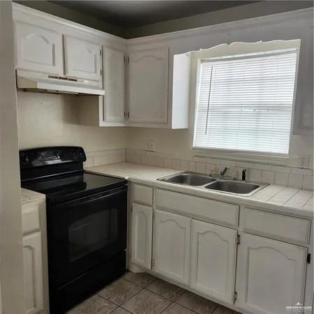 a kitchen with cabinets appliances a sink and a window
