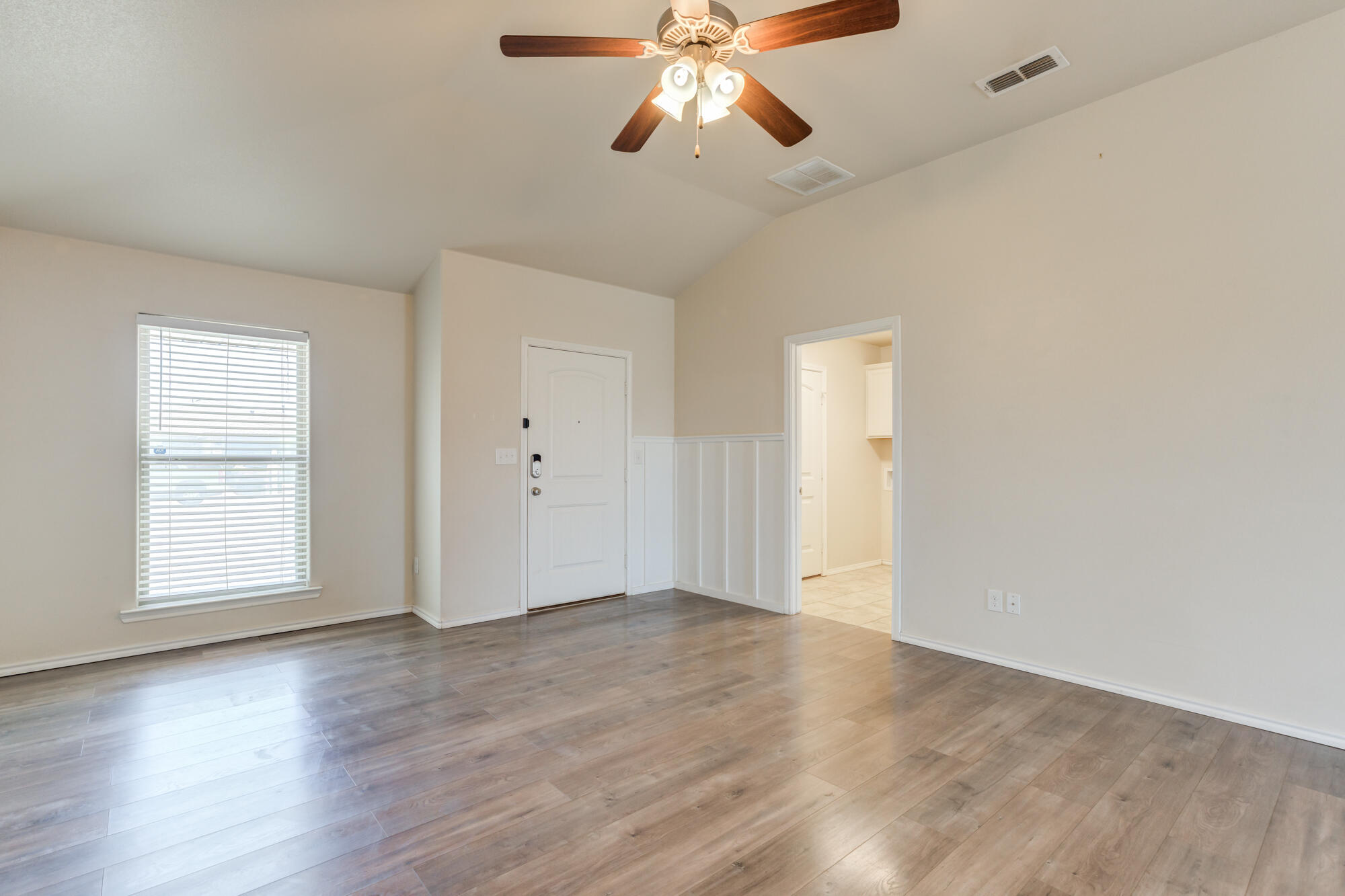 7012 34th Place Lubbock, TX 79407 - Photo 11 of 36 an empty room with wooden floor ceiling fan and windows