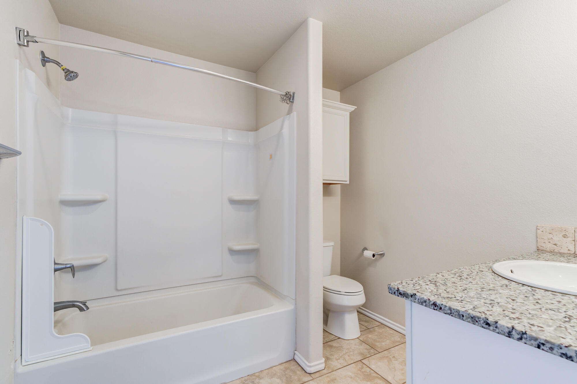 7012 34th Place Lubbock, TX 79407 - Photo 26 of 36 a bathroom with a granite countertop bathtub shower sink and toilet