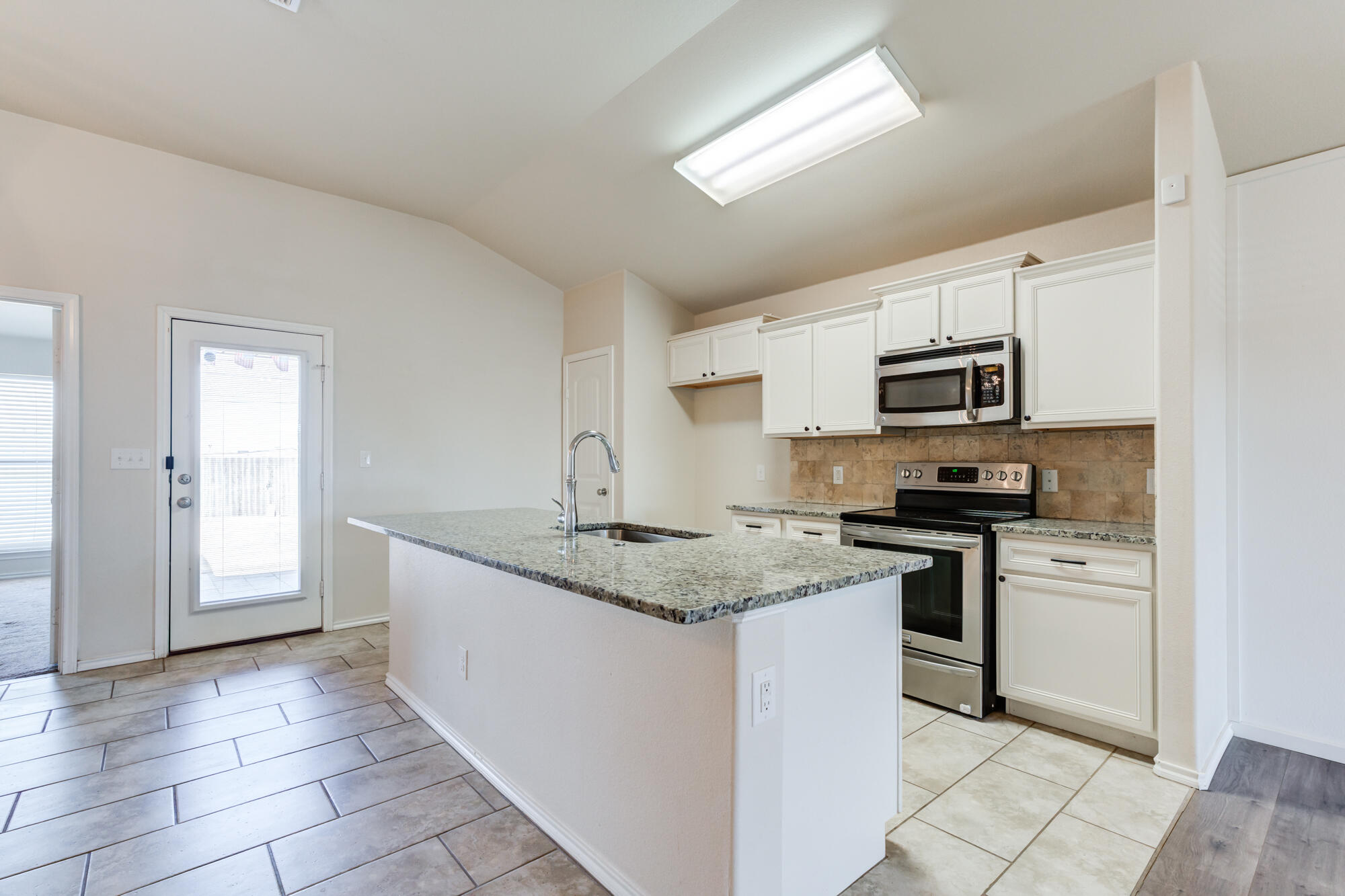 7012 34th Place Lubbock, TX 79407 - Photo 3 of 36 a kitchen with stainless steel appliances granite countertop a sink stove and microwave