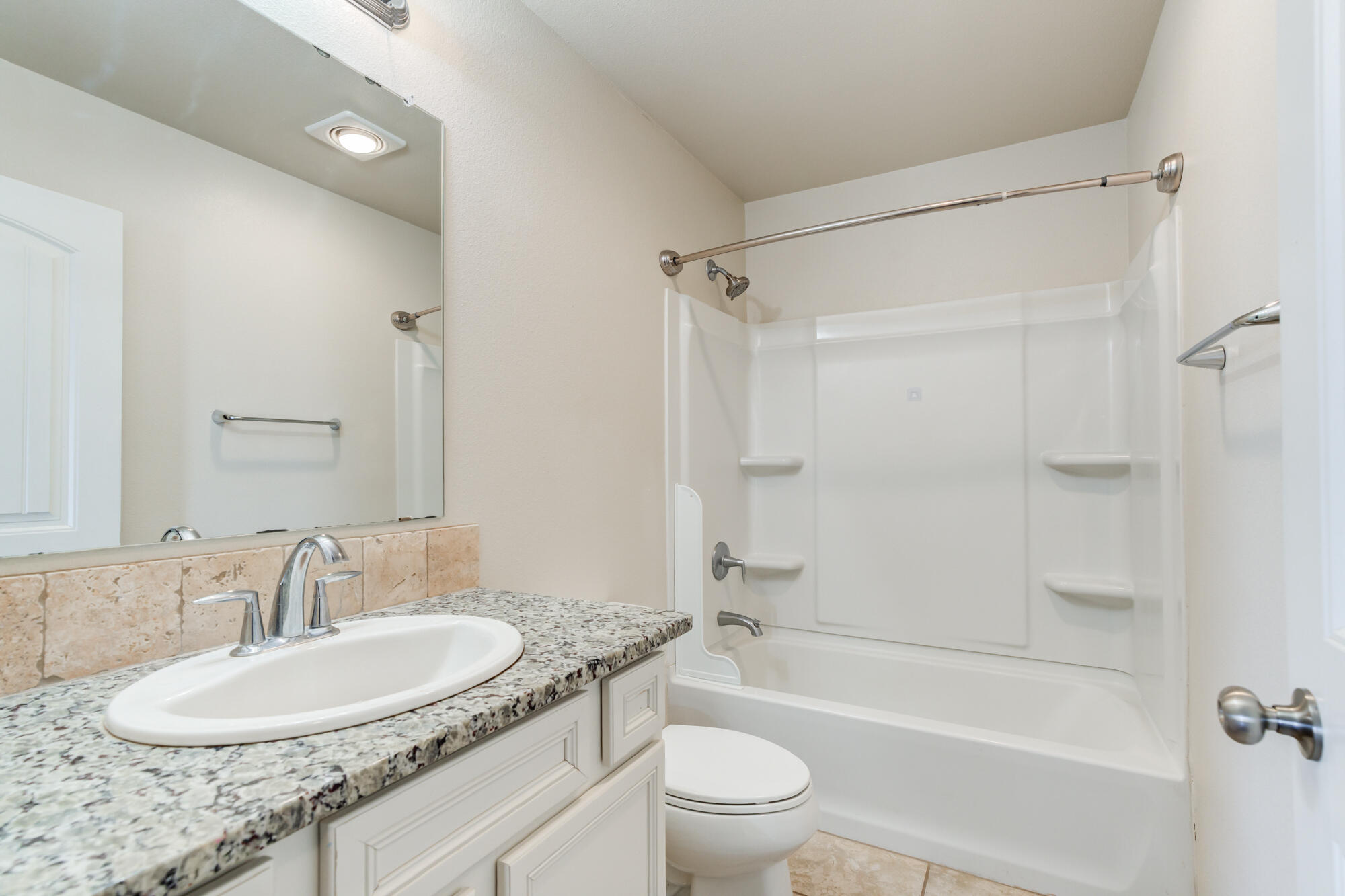 7012 34th Place Lubbock, TX 79407 - Photo 32 of 36 a bathroom with a granite countertop sink toilet mirror and shower