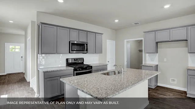 a kitchen with stainless steel appliances granite countertop a refrigerator a stove and a sink