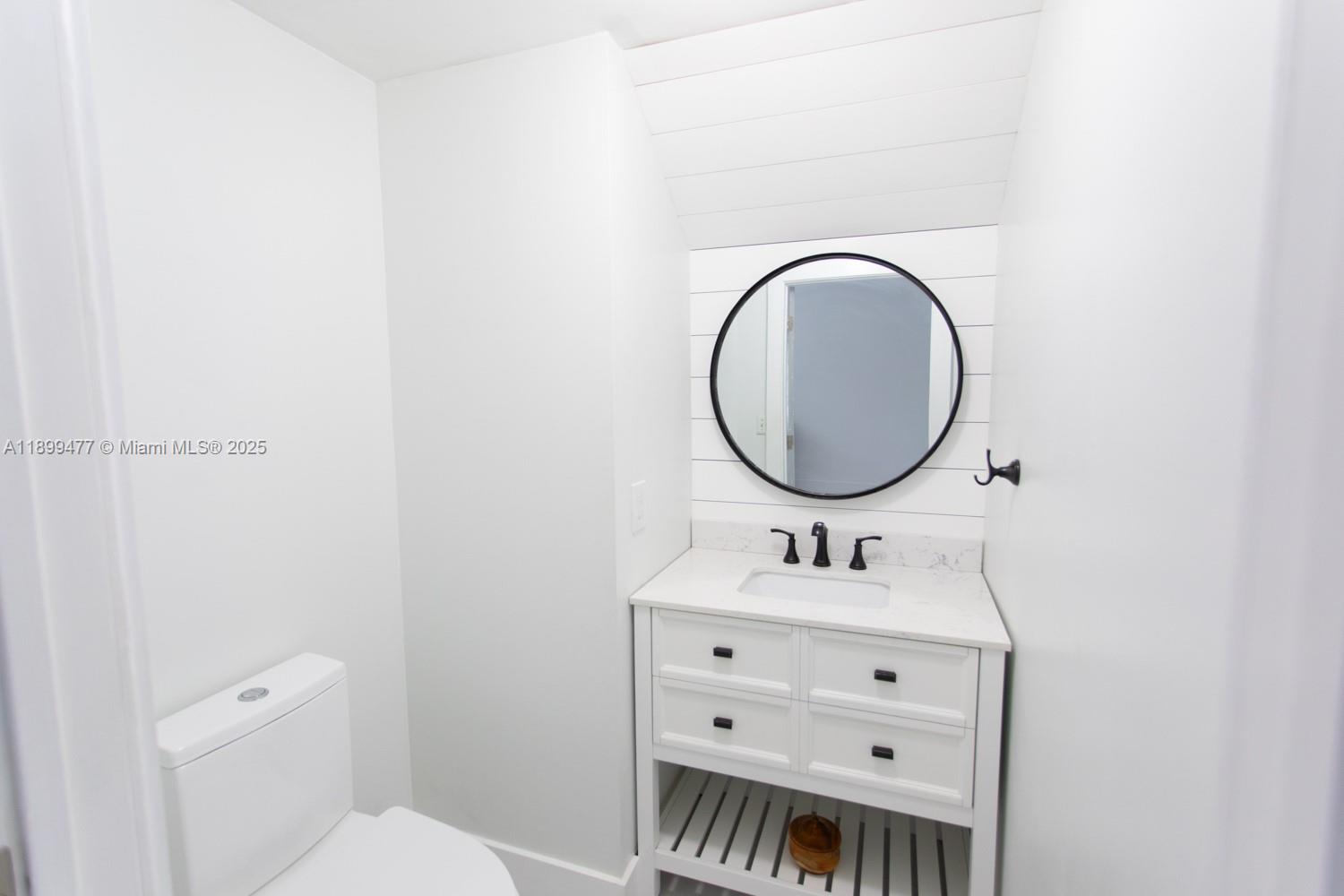 14219 Southwest 126th Place Miami, FL 33186 - Photo 11 of 26 a bathroom with a toilet sink and mirror