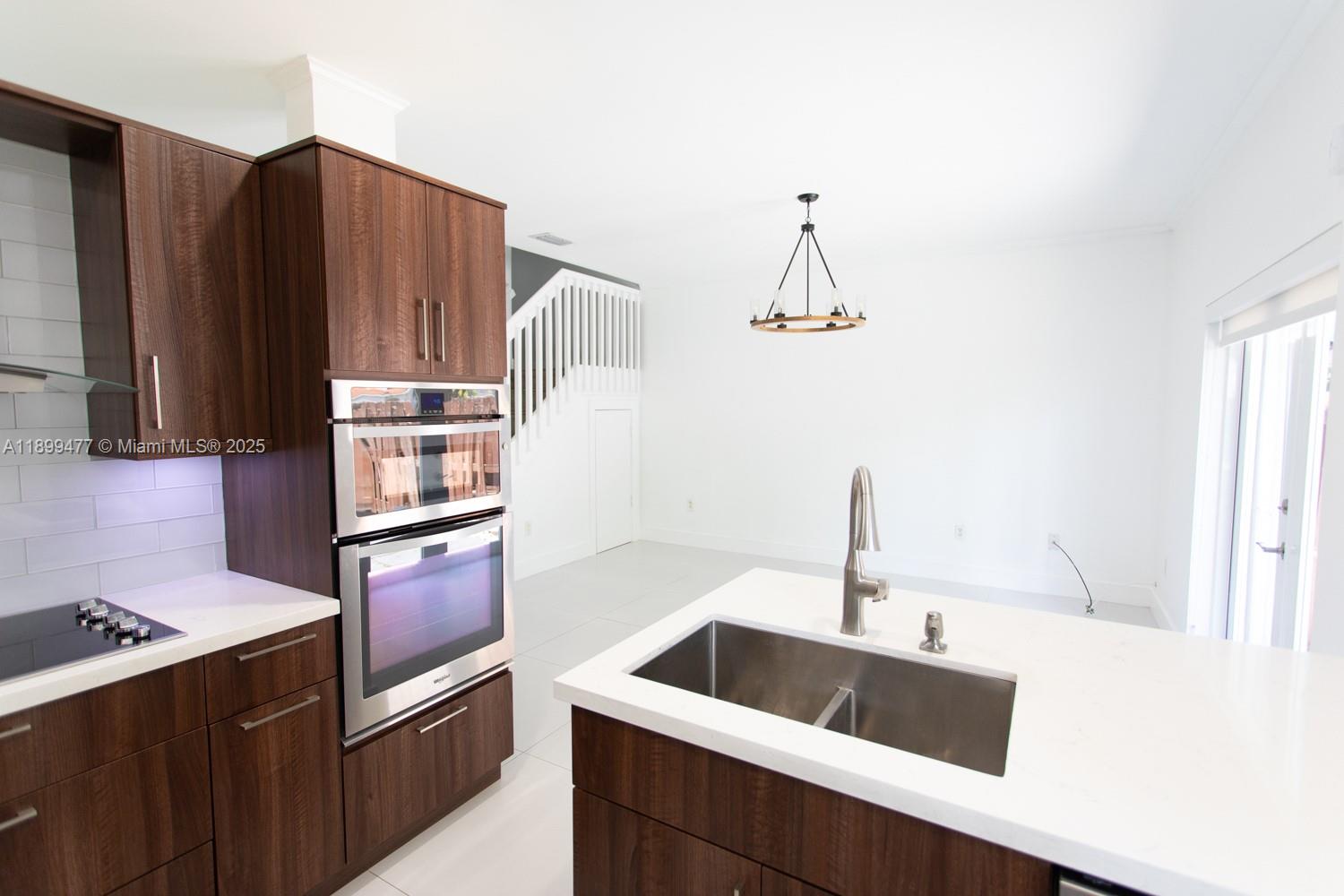 14219 Southwest 126th Place Miami, FL 33186 - Photo 10 of 26 a kitchen with granite countertop a sink and a refrigerator