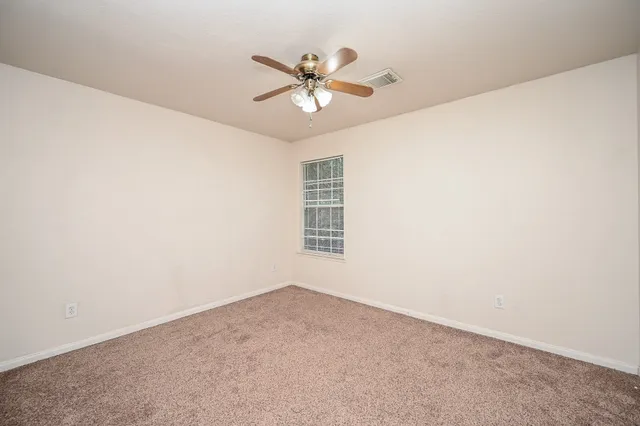 an empty room with a window and a fan
