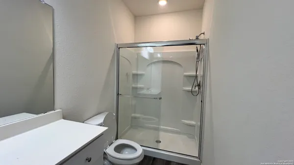 a bathroom with a sink a toilet and shower