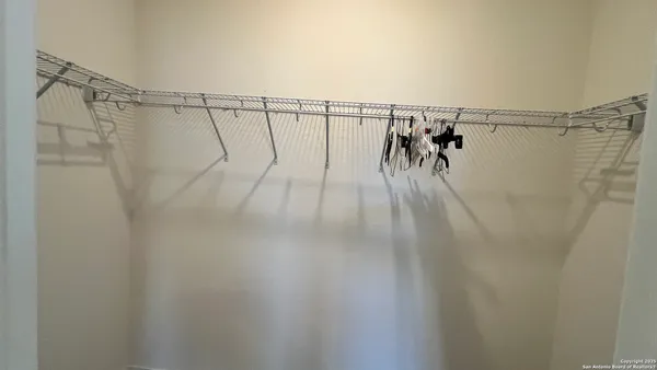 a walk in closet with a white rack